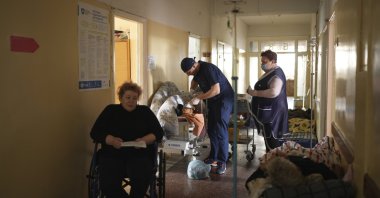 A medical worker (C) treats a man wounded by shelling in a hospital in Mariupol, Ukraine, March 4, 2022. (AP Photo)