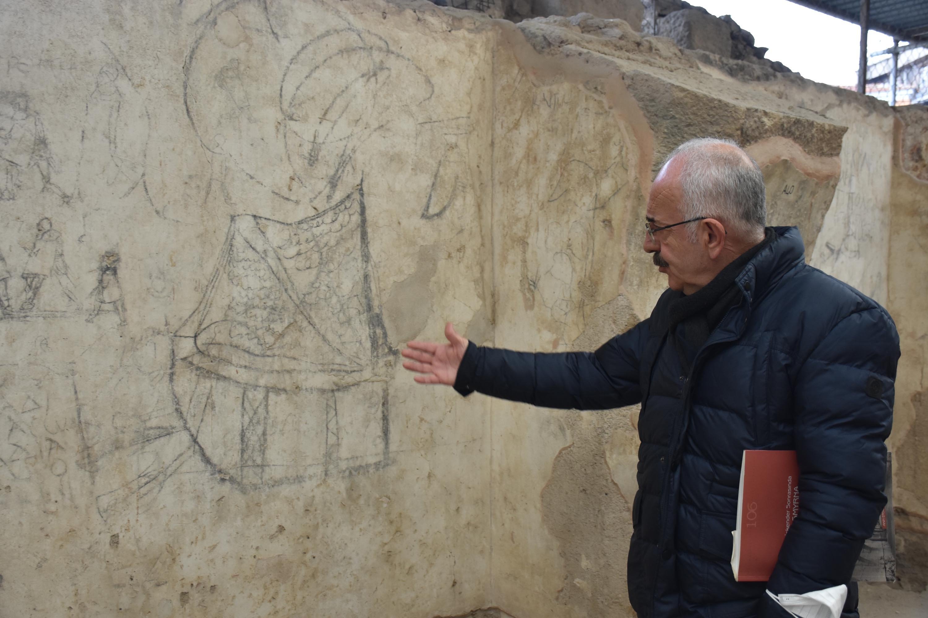 Izmir Katip elebi University Anggota fakultas Turki dan Arkeologi Islam Akın Ersoy berbicara tentang grafiti kapal yang ditemukan di ruang bawah tanah basilika, Agora of Smyrna, Izmir, Turki barat daya, 9 Maret 2022. (Foto DHA)