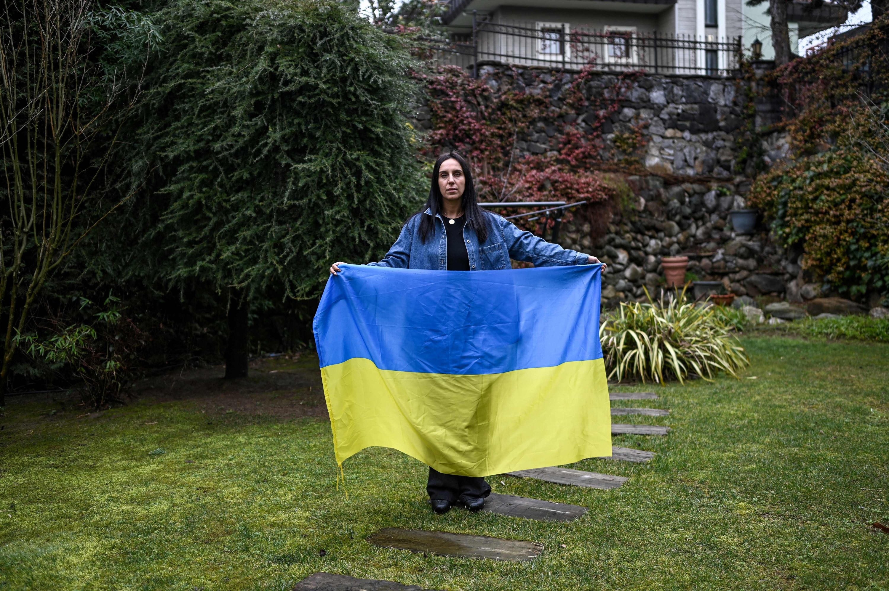 Pemenang kontes lagu Eurovision 2016, Susana Jamaladinova, yang dikenal sebagai 'Jamala' berpose dengan bendera nasional Ukraina selama wawancara AFP di Istanbul, 7 Maret 2022. (AFP)