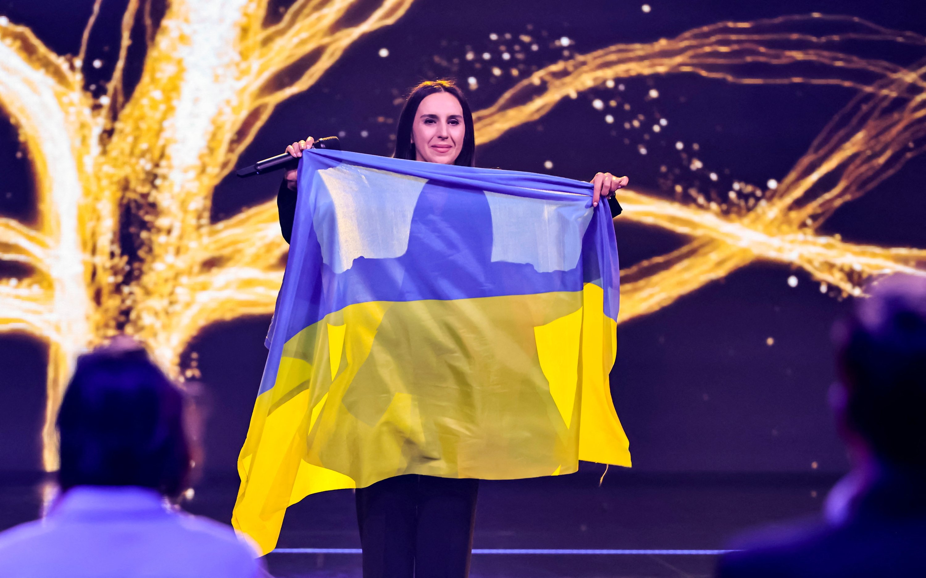 Penyanyi Ukraina Jamala, pemenang Kontes Lagu Eurovision pada 2016 dan yang melarikan diri dari perang di negaranya, memegang bendera saat dia tampil di 'Jerman 12 Poin,' babak penyisihan Jerman Kontes Lagu Eurovision, di Berlin, Jerman, Maret 4, 2022. (REUTERS)