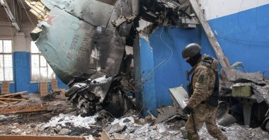 A Ukrainian soldier walks past the vertical tail fin of a Russian Su-34 bomber lying in a damaged building in Kharkiv, Ukraine, March 8, 2022. (AP Photo)