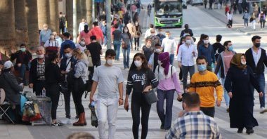People wearing protective masks against COVID-19 walk on a street in Denizli, western Turkey, March 4, 2022. (IHA PHOTO)