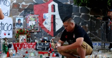 A fan of Mexican football team Atlas lights a candle during a mass outside Jalisco Stadium in Guadalajara, Mexico, March 7, 2022 (AFP Photo)