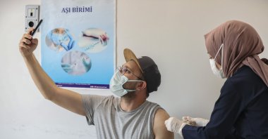 A man takes a selfie as he gets vaccinated against COVID-19 at a hospital in the capital Ankara, Turkey, Jun. 15, 2021. (AA PHOTO)