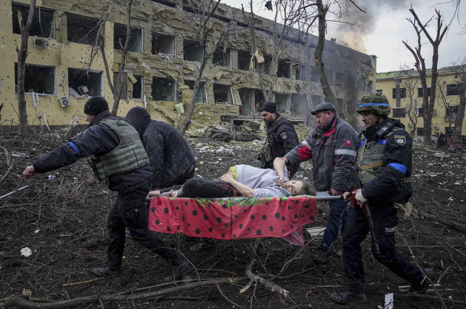 Ukrainian emergency employees and volunteers carry an injured pregnant woman from a maternity hospital that was damaged by shelling in Mariupol, Ukraine, March 9, 2022. (AP Photo)