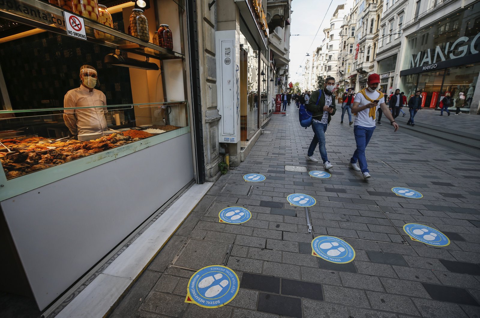 A restaurant worker waits for customers at a restaurant on Istiklal Avenue, the main shopping street in Istanbul, Turkey, June 1, 2020. (AP Photo)