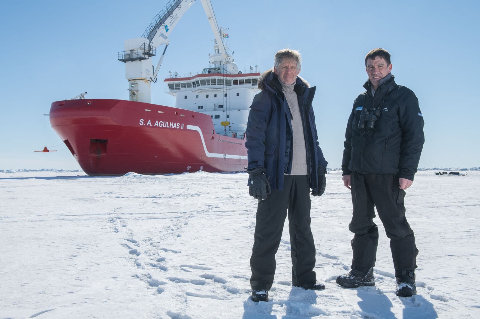 Menson Bound, director of exploration of the Endurance22 expedition (L) and John Shears, expedition leader, with SA Agulhas II in the background, on the Weddell Sea, Antarctica, Feb. 20, 2022. (Falklands Maritime Heritage Trust via AFP)