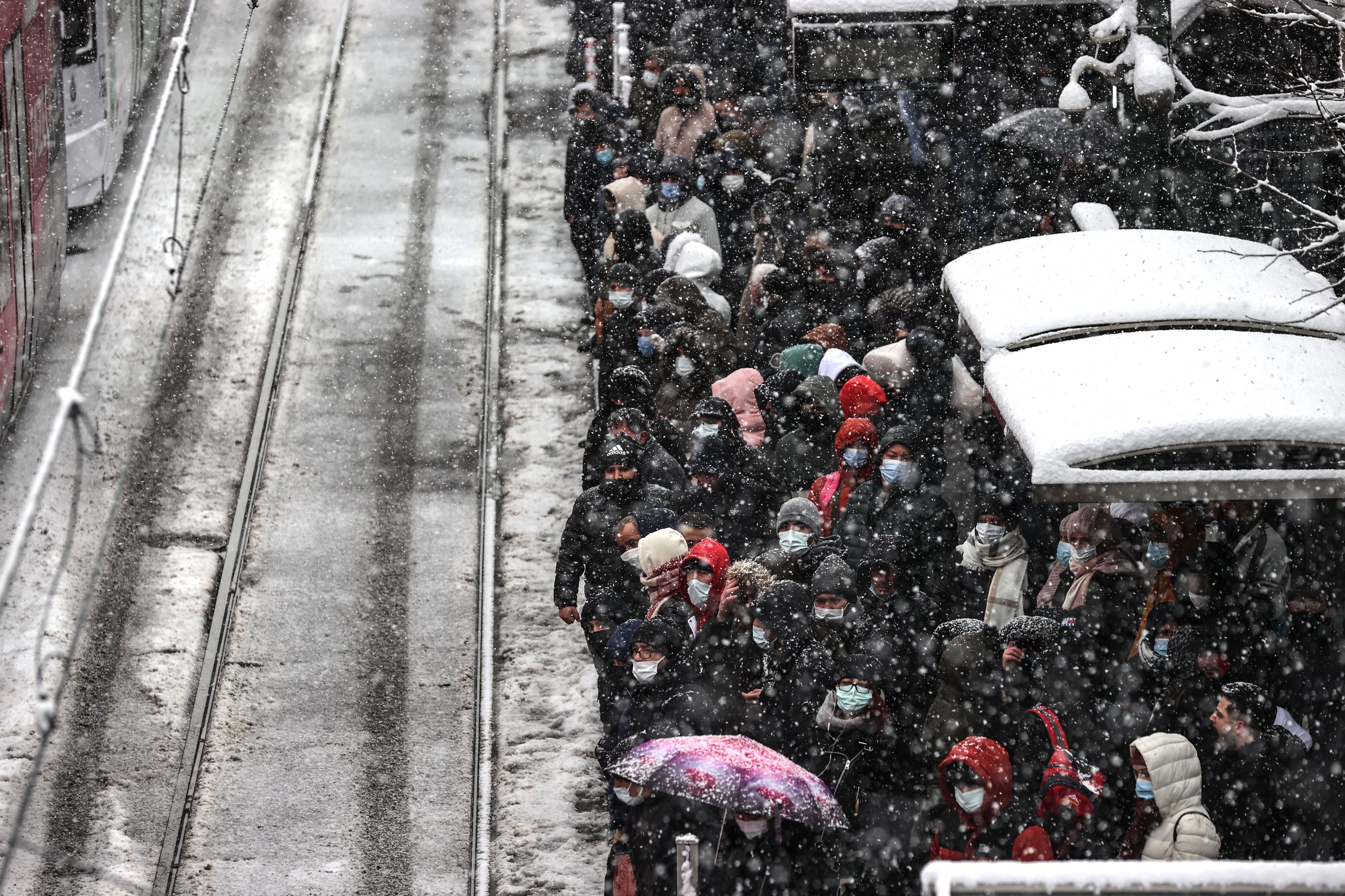 Orang-orang menunggu di stasiun trem di tengah hujan salju di lingkungan Aksaray, di Istanbul, Turki, 11 Maret 2022. (AA PHOTO)