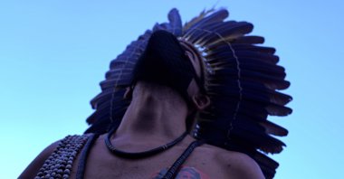 An indigenous Pataxo man with a sticker on his chest that reads in Portuguese "Out Bolsonaro," participates in a demonstration by the "Act for the Earth" movement in front of the National Congress in Brasilia, Brazil, March 9, 2022. (AP Photo)
