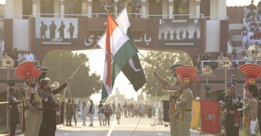 Indian Border Security Force personnel (in brown uniforms) and Pakistani Rangers (in black uniforms) take part in the beating retreat ceremony at the India-Pakistan Wagah border post, March 9, 2022. (AFP Photo)