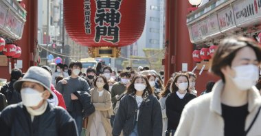 People wearing face masks to protect against the spread of the coronavirus walk through a shopping arcade in the Asakusa district in Tokyo, Japan, March 7, 2022. (AP Photo)