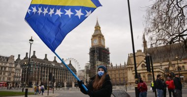 A demonstrator waves a flag during a rally to raise awareness of a potential new Bosnian crisis, at Parliament Square in London, U.K., Jan. 10, 2022. (AP Photo)