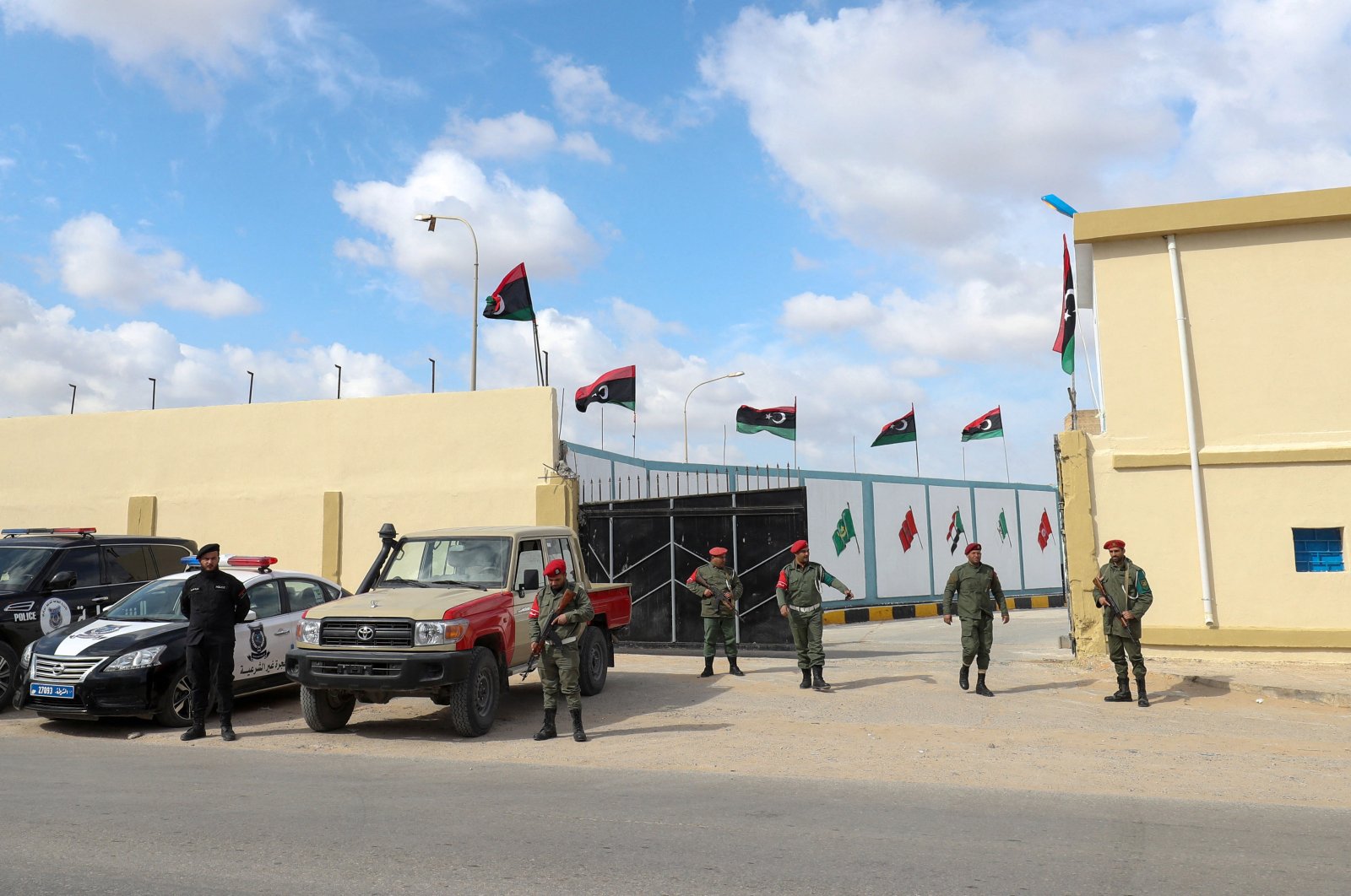 Libyan security forces stand guard outside a newly-opened shelter for migrants in the capital Tripoli on March 9, 2022. - More than 1,160 migrants died at sea attempting to reach Europe from North Africa in the first half of 2021, up 155 percent year-on-year, the UN's migration agency said. (Photo by Mahmud Turkia / AFP)