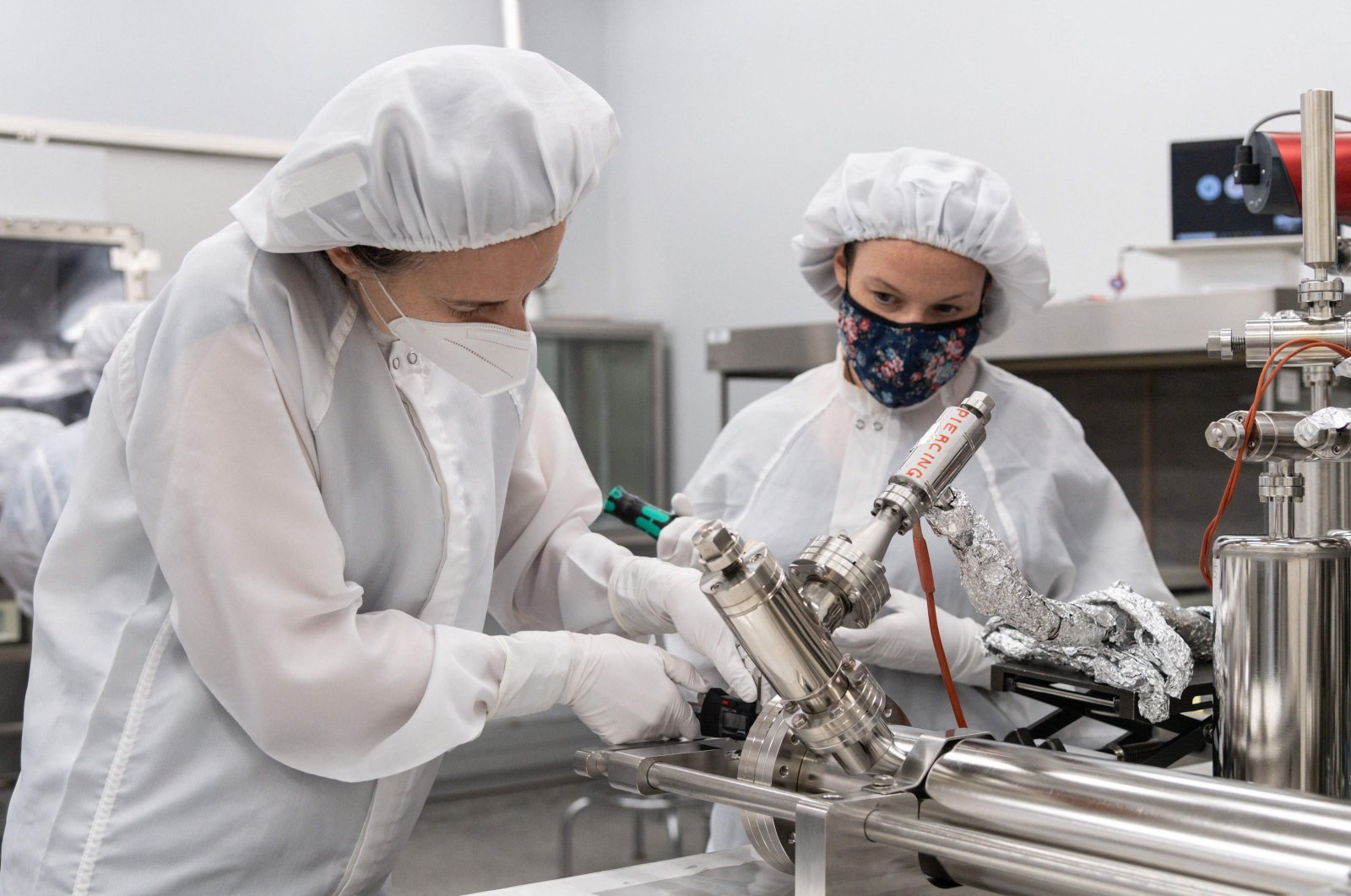 Juliane Gross (L) and Francesca McDonald, take precise measurements from a piercing device, at NASA&#039;s Johnson Space Center in Houston, Texas, U.S., Feb. 23, 2022. (NASA via AFP)