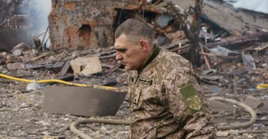 Ukraine army public affairs officer Valentin Yermolenko walks in front of a destroyed shoe factory following in what appears to be the first direct airstrike in Dnipro, central Ukraine, March 11, 2022. (AFP Photo)