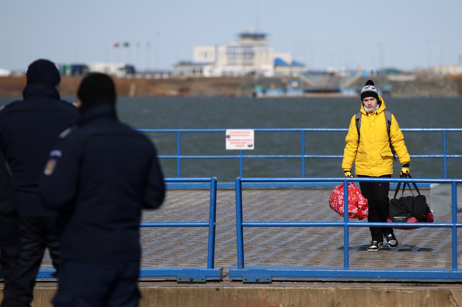 A boy holds his luggage, as he arrives by ferry after fleeing from Russia&#039;s invasion of Ukraine, at the Isaccea-Orlivka border crossing, Romania, March 12, 2022. (Reuters Photo)