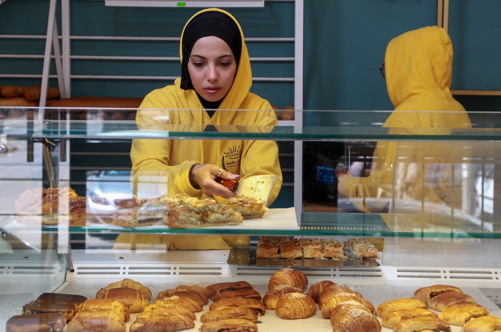 A staff member arranges baked goods at a bakery that is unsubsidized by the Tunisian state, in the capital Tunis, on March 11, 2022. (AFP Photo)