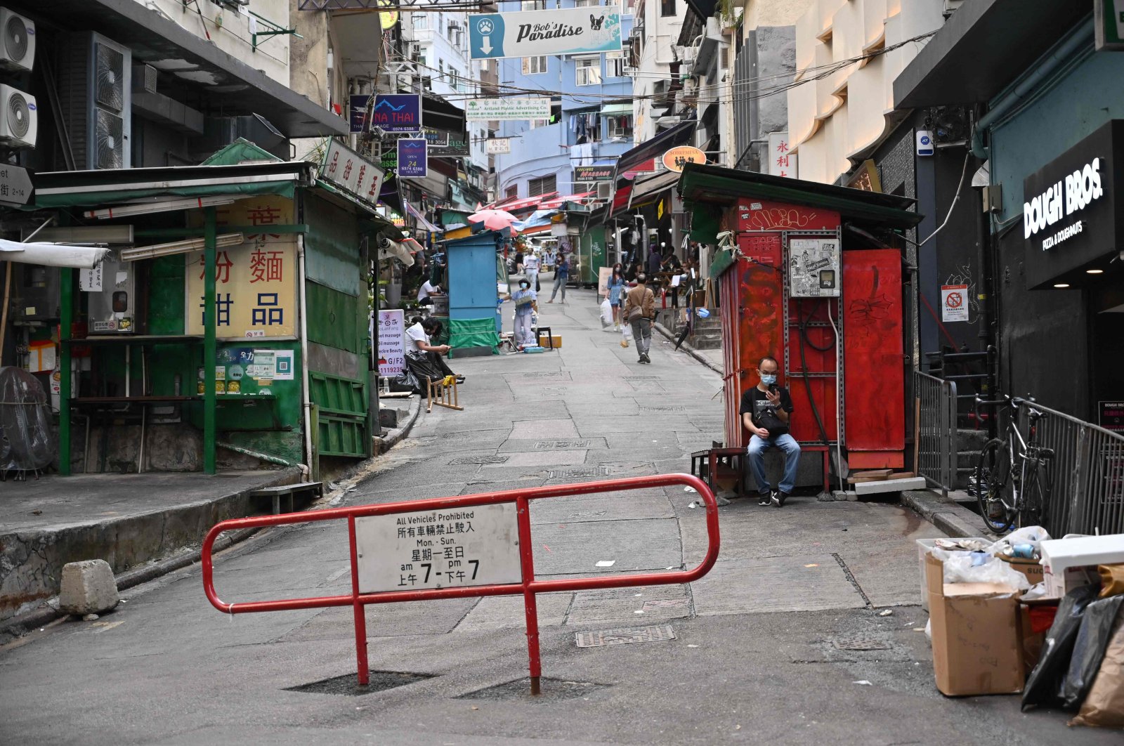 A man looks at his phone on an empty street in Hong Kong on March 13, 2022. (AFP Photo)
