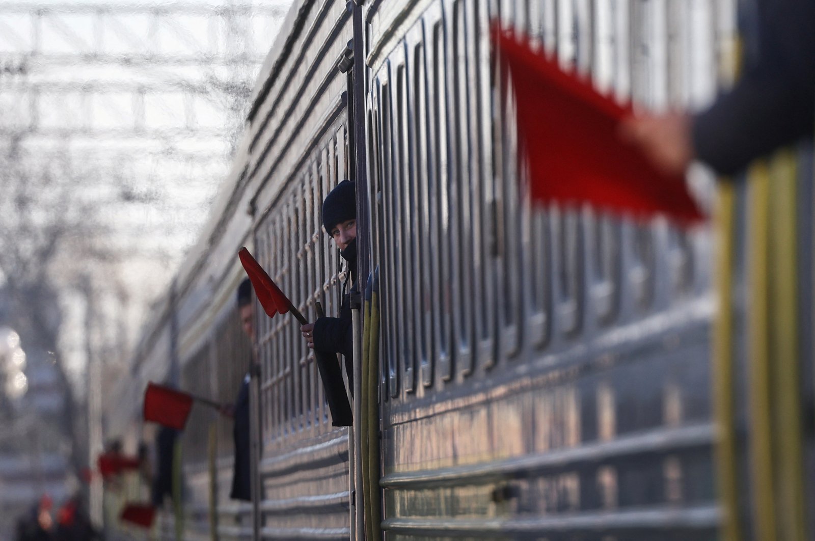 Train conductors hold up a red flag to prevent people from entering a train that brought refugees from northeastern Ukraine fleeing the ongoing Russian invasion, at a train station in Lviv, Ukraine, March 12, 2022.  (Reuters Photo)