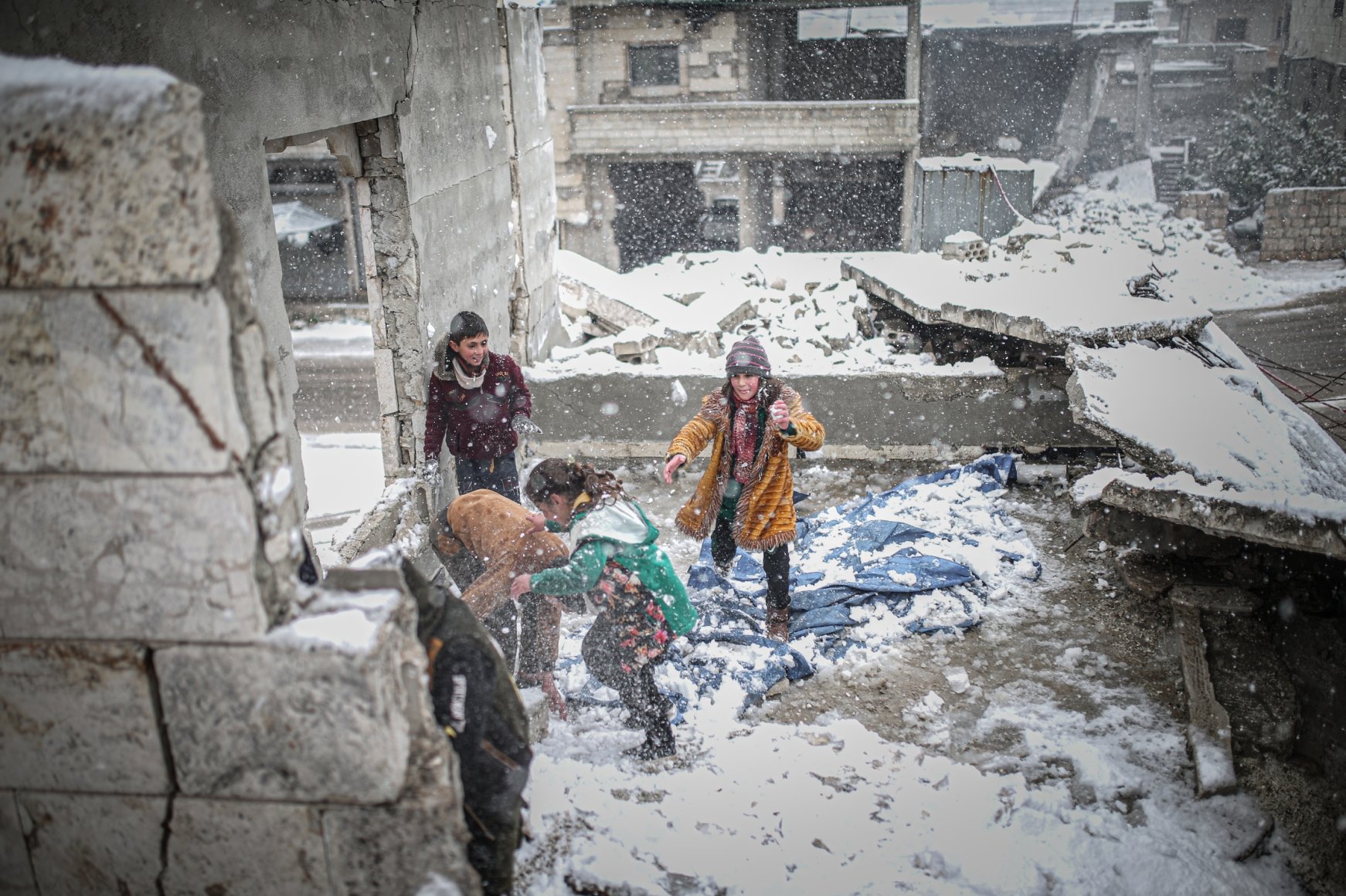 Laughter amid heartache: Snowfall blankets Syria's war-torn Idlib ...