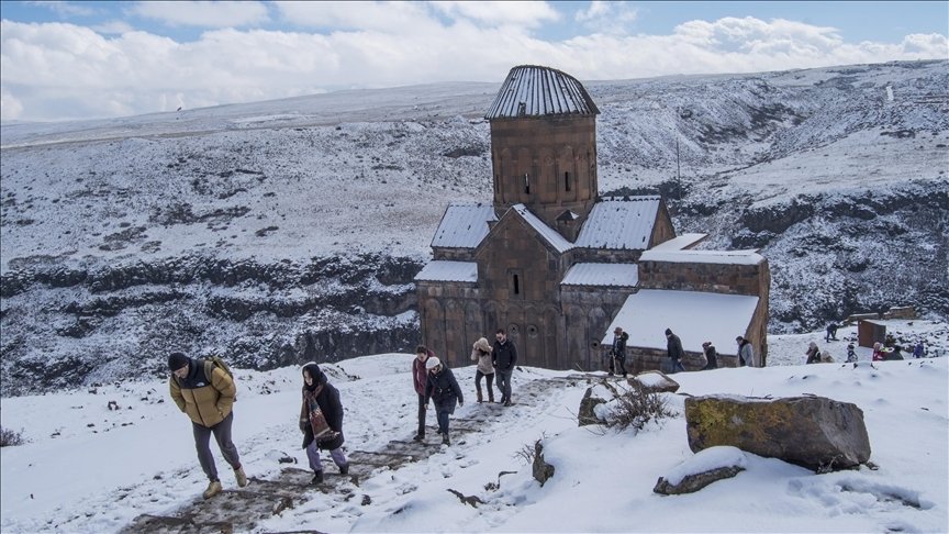 A group of tourists walk in front of the Monastery of the Hripsimian Virgins, Kars, Turkey, March 14, 2022. (AA Photo)
