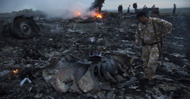 People walk amongst the debris at the crash site of a passenger plane near the village of Grabovo, Ukraine, July 17, 2014. (AP Photo)