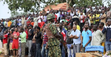 A soldier stands guard as the crowd looks on at the scene of a car bomb attack in Nyanya, Abuja, Nigeria, May 2, 2014. (Reuters Photo)