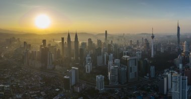 The sun rises in the background of the city center in Kuala Lumpur, Malaysia, Jan. 21, 2022. (AP Photo)