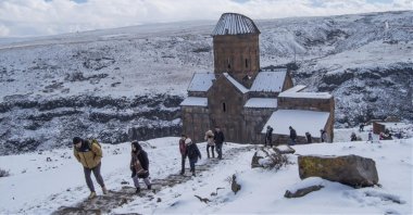 A group of tourists walk in front of the Monastery of the Hripsimian Virgins, Kars, Turkey, March 14, 2022. (AA Photo)