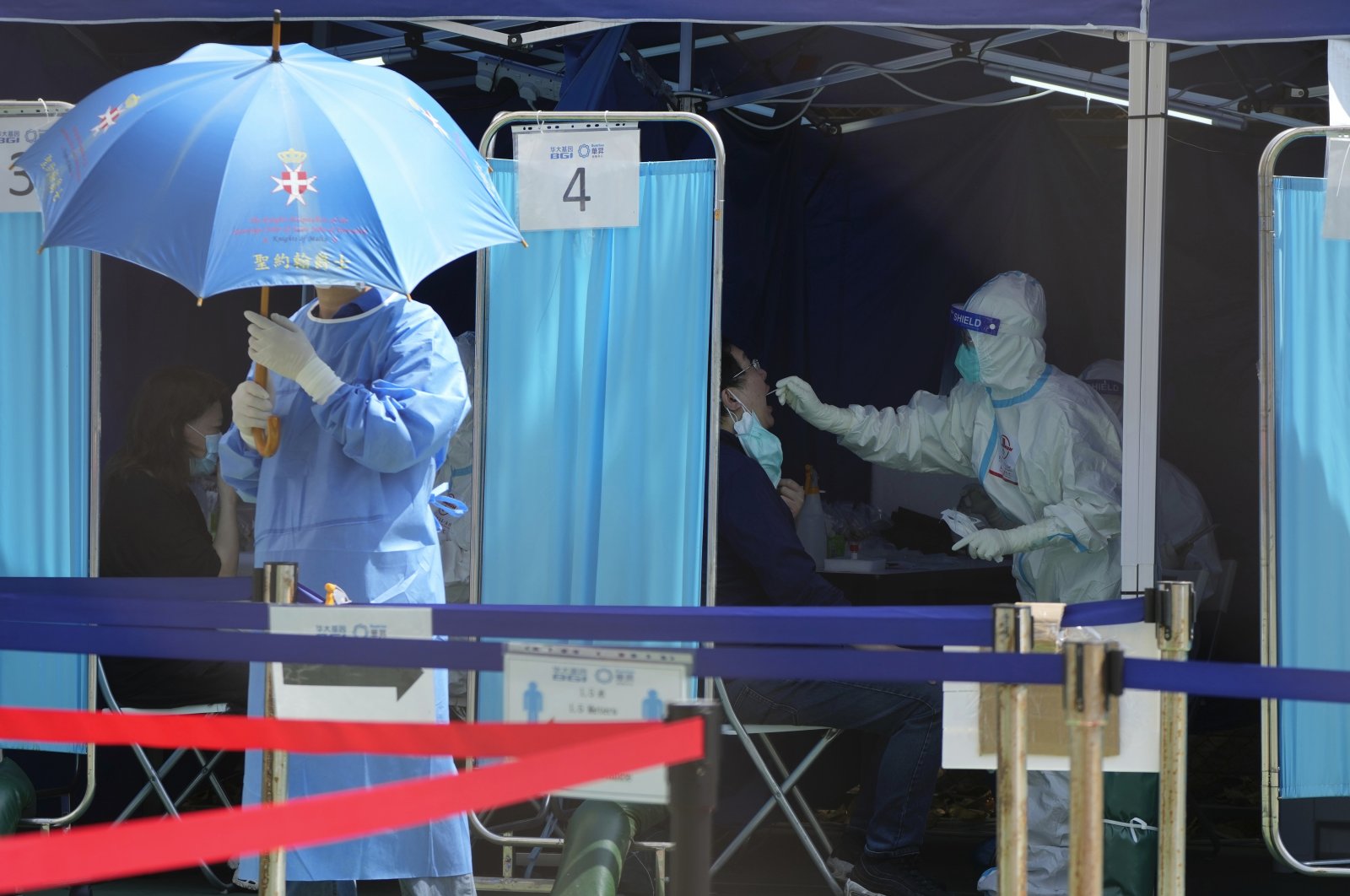 Medical workers help residents get tested for the coronavirus at a temporary testing center in Hong Kong, China, March 14, 2022. (AP Photo)