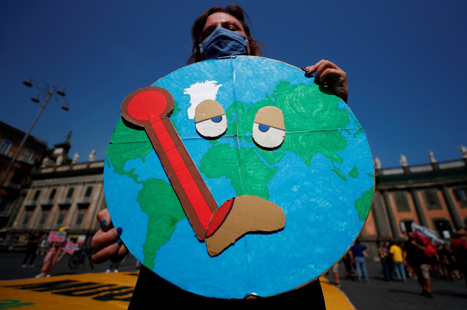 A person holds a placard as climate activists including Extinction Rebellion and Fridays for Future stage a protest demanding more action while G-20 climate and environment ministers hold a meeting in Naples, Italy, July 22, 2021. (Reuters Photo)