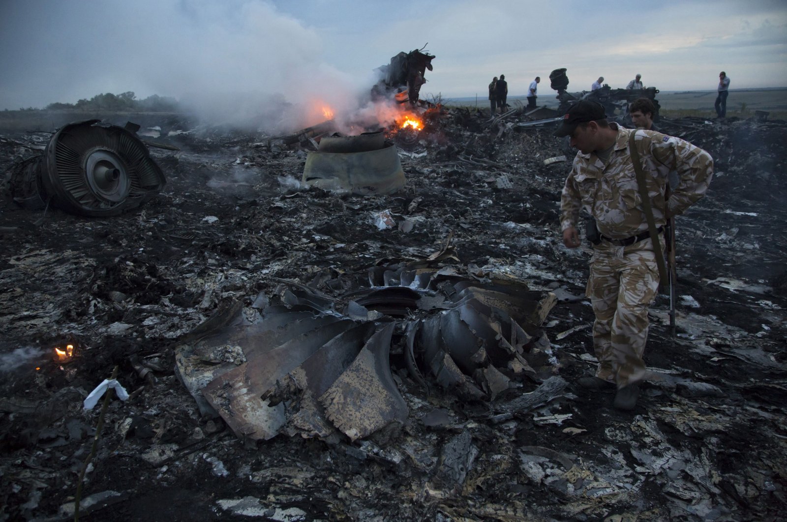 People walk amongst the debris at the crash site of a passenger plane near the village of Grabovo, Ukraine, July 17, 2014. (AP Photo)