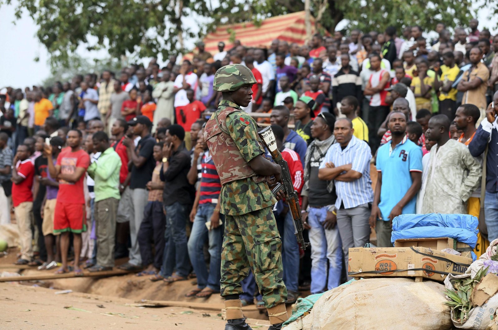 A soldier stands guard as the crowd looks on at the scene of a car bomb attack in Nyanya, Abuja, Nigeria, May 2, 2014. (Reuters Photo)