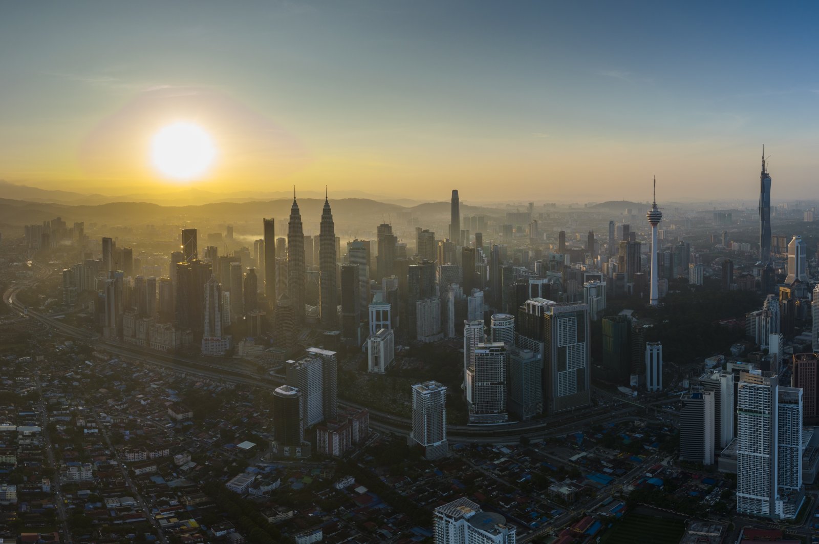 The sun rises in the background of the city center in Kuala Lumpur, Malaysia, Jan. 21, 2022. (AP Photo)