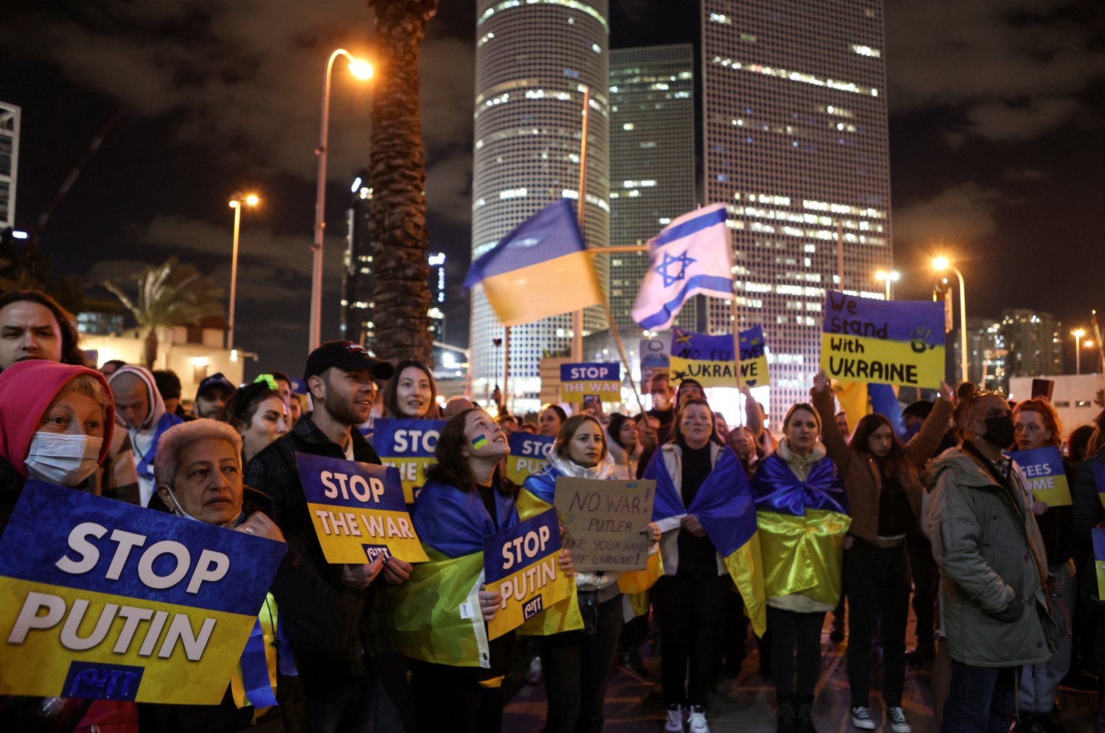 Protestors hold signs at a demonstration against the Russian military invasion of Ukraine, calling on Russian President Vladimir Putin to stop the war, in Tel Aviv, Israel, March 12, 2022. (REUTERS Photo)