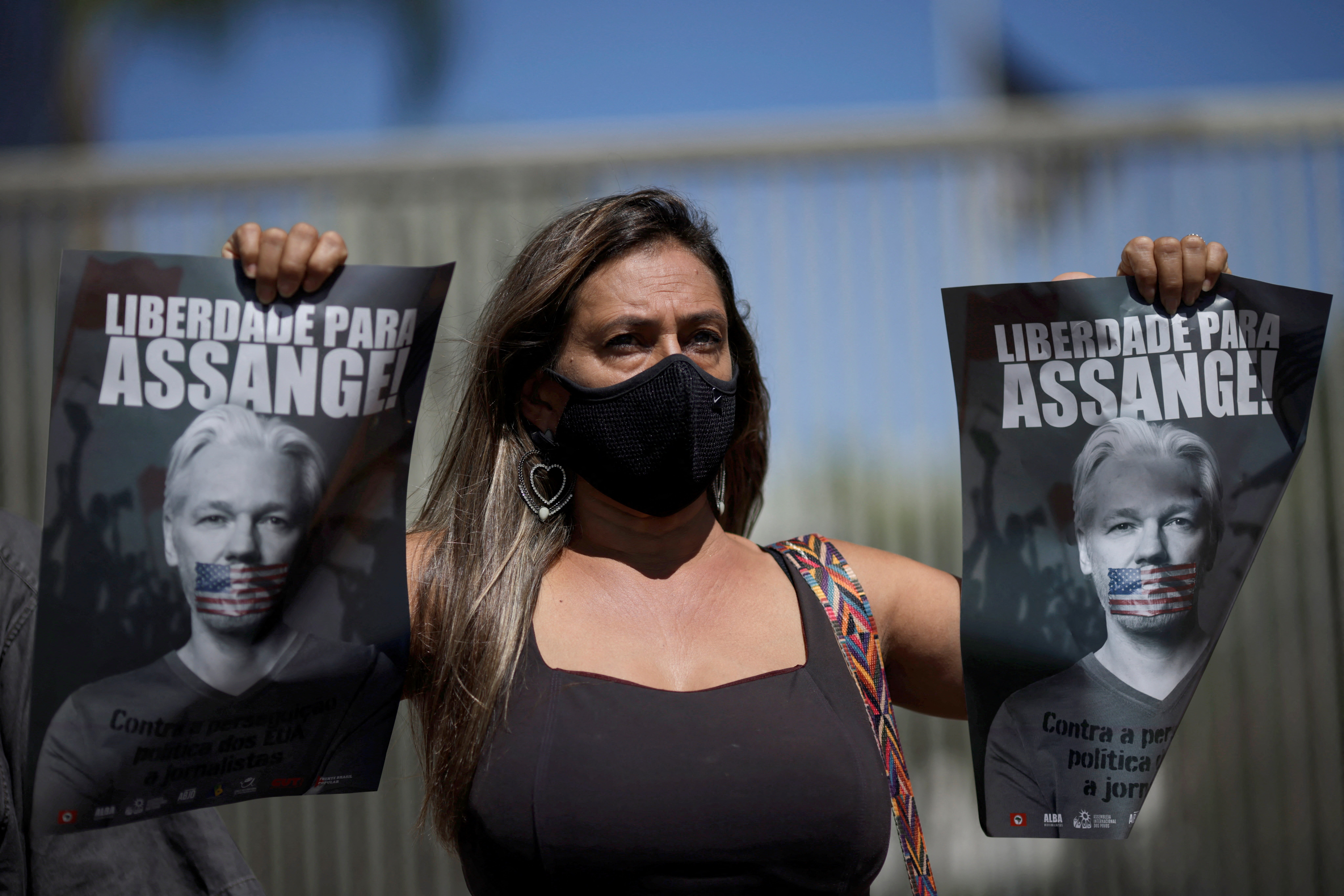 A supporter of WikiLeaks founder Julian Assange holds placards during a protest against his extradition to the U.S., outside the United States Embassy in Brasilia, Brazil Feb. 25, 2022. (Photo via REUTERS)