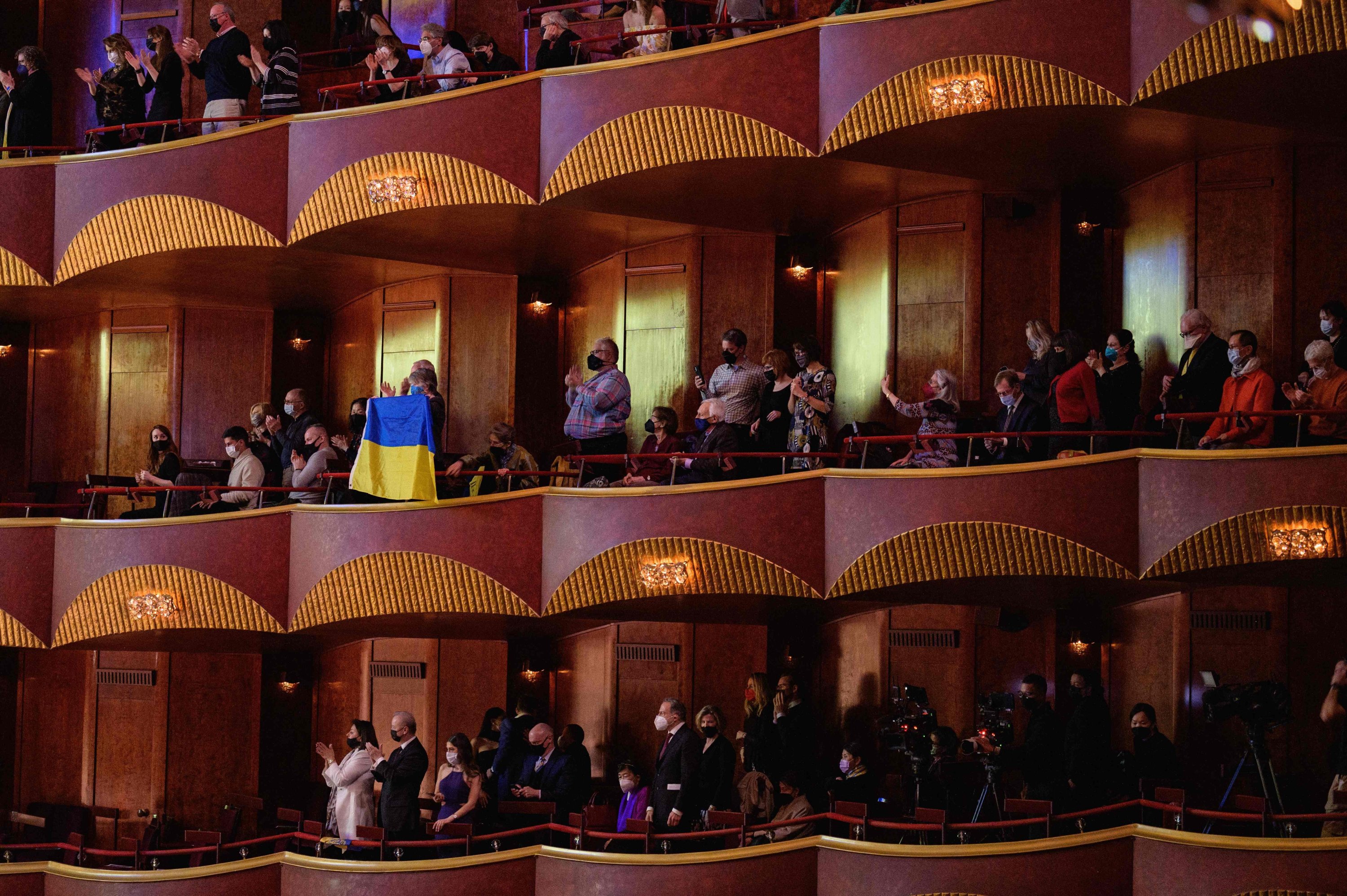 Penonton mengangkat bendera Ukrania selama 