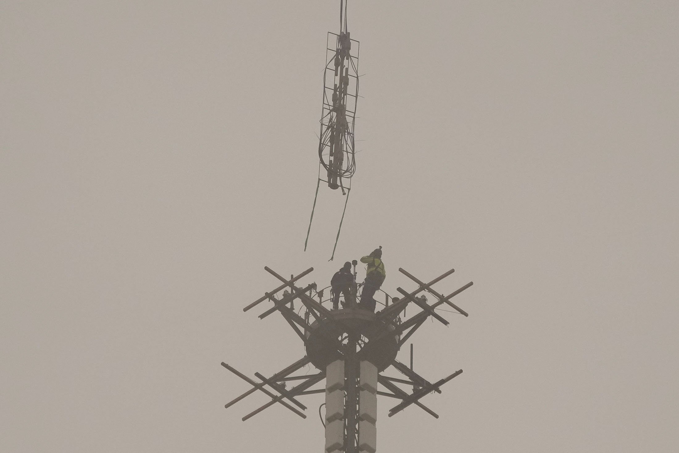 Helikopter Eurocopter Ecureuil 2 memasang antena transmisi telekomunikasi baru TDF (TeleDiffusion de France) di atas Menara Eiffel di Paris, Prancis, 15 Maret 2022. (AP Photo)