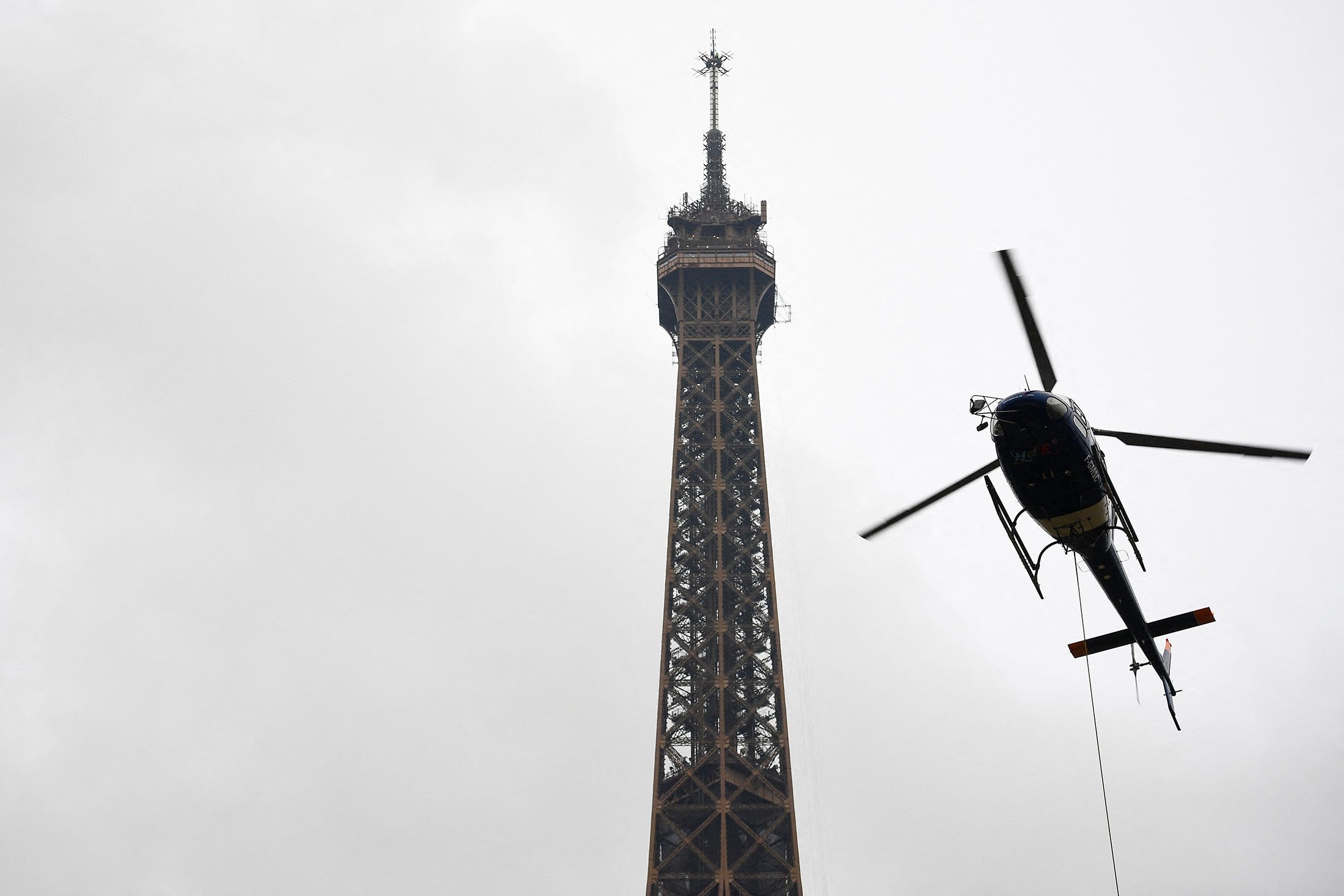 Antena baru dipasang oleh Eurocopter AS355N Ecureuil 2 di puncak Menara Eiffel, di Paris, Prancis, 15 Maret 2022. (AFP Photo)
