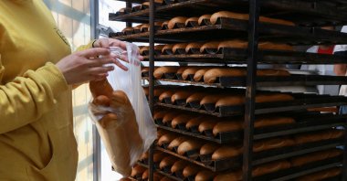 A staff member fetches freshly-baked bread at an unsubsidized bakery, in the capital Tunis, on March 11, 2022. (AFP File Photo)