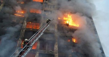 Firefighters work to extinguish a fire in a housing block hit by shelling in the Sviatoshynskyi district in western Kyiv, Ukraine, March 15, 2022. (State Emergency Service of Ukraine Handout Photo via AFP)
