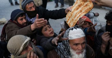 People reach out to receive bread, in Kabul, Afghanistan, Jan. 31, 2022. (Reuters Photo)