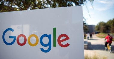 In this file photo taken on November 04, 2016, a man rides a bike passed a Google sign and logo at the Googleplex in Mountain View, California. (AFP Photo)