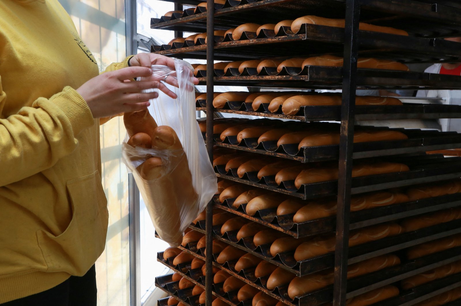 A staff member fetches freshly-baked bread at an unsubsidized bakery, in the capital Tunis, on March 11, 2022. (AFP File Photo)