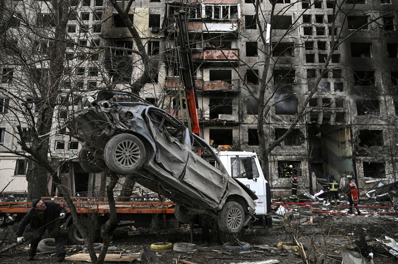 A crane removes a ruined car from in front of a destroyed apartment building after it was shelled by Russia, in Kyiv, Ukraine, March 14, 2022. (AFP Photo)