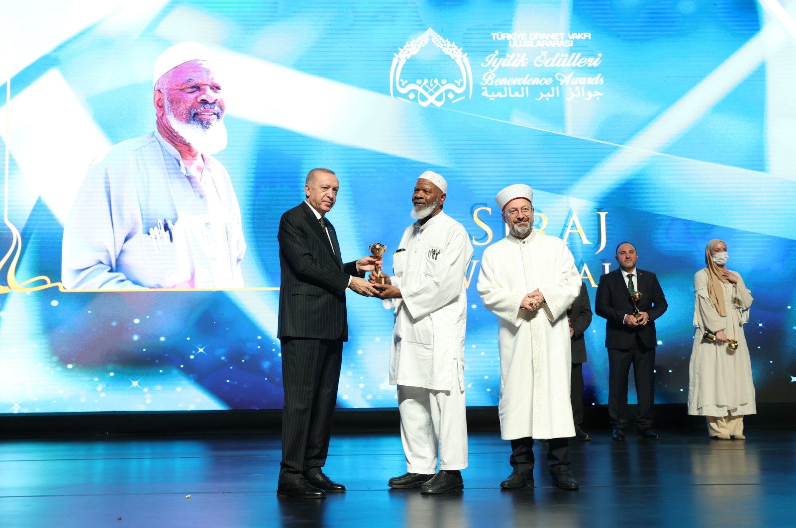 President Recep Tayyip Erdoğan (L) presents the benevolence award to Siraj Wahhaj (C) at the ceremony in the capital Ankara, Turkey, March 15, 2022. (AA Photo)