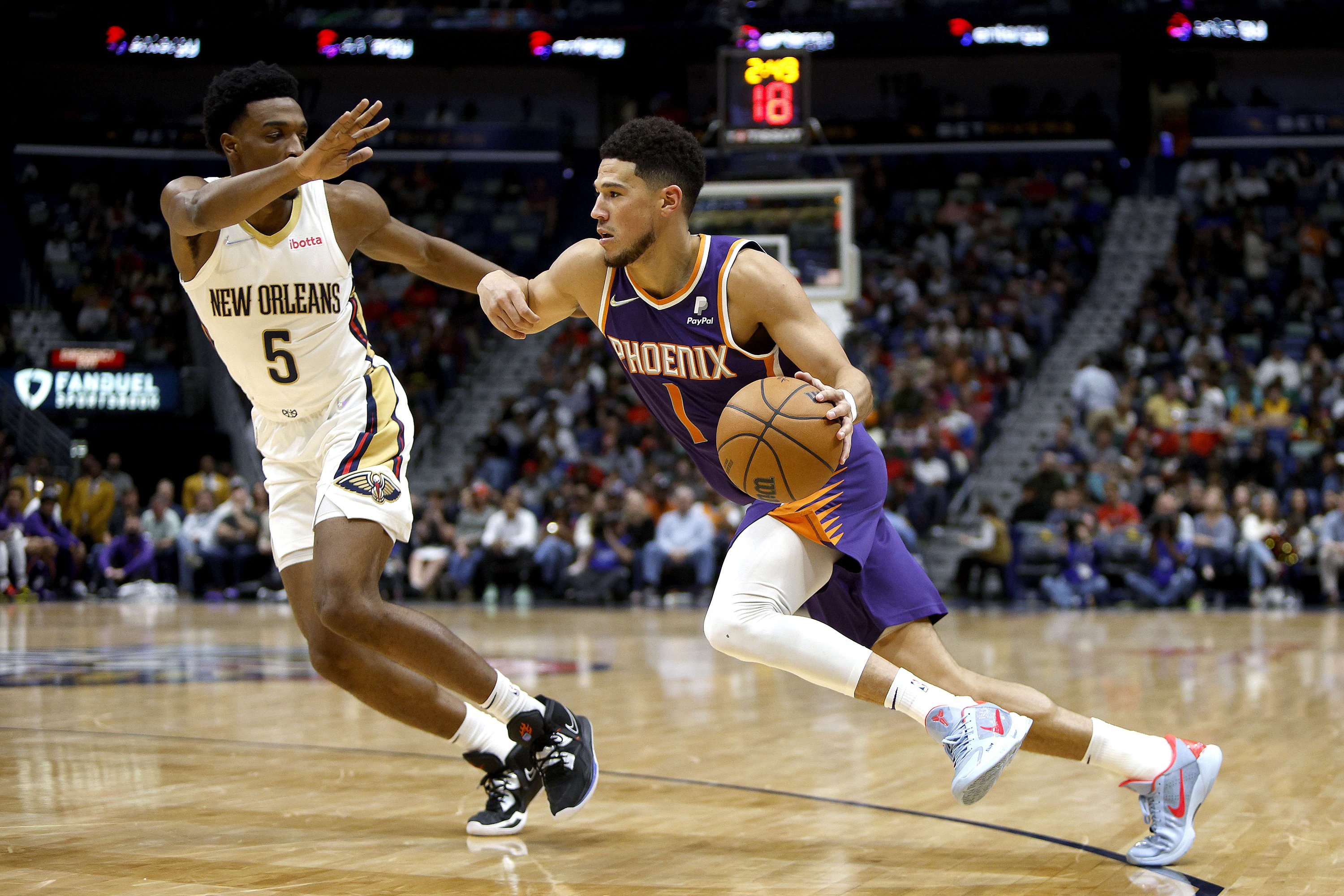 Devin Booker (kanan) Suns bersaing dengan Herbert Jones dari Pelicans dalam pertandingan NBA, New Orleans, Louisiana, AS, 15 Maret 2022. (AFP Photo)