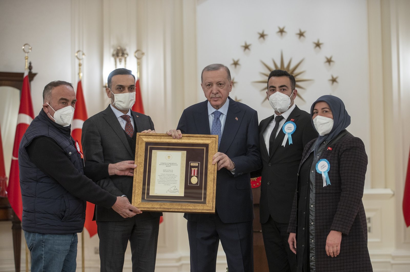 President Recep Tayyip Erdoğan (C) presents medals to families of fallen soldiers at the ceremony in the capital Ankara, Turkey, March 16, 2022. (AA PHOTO)