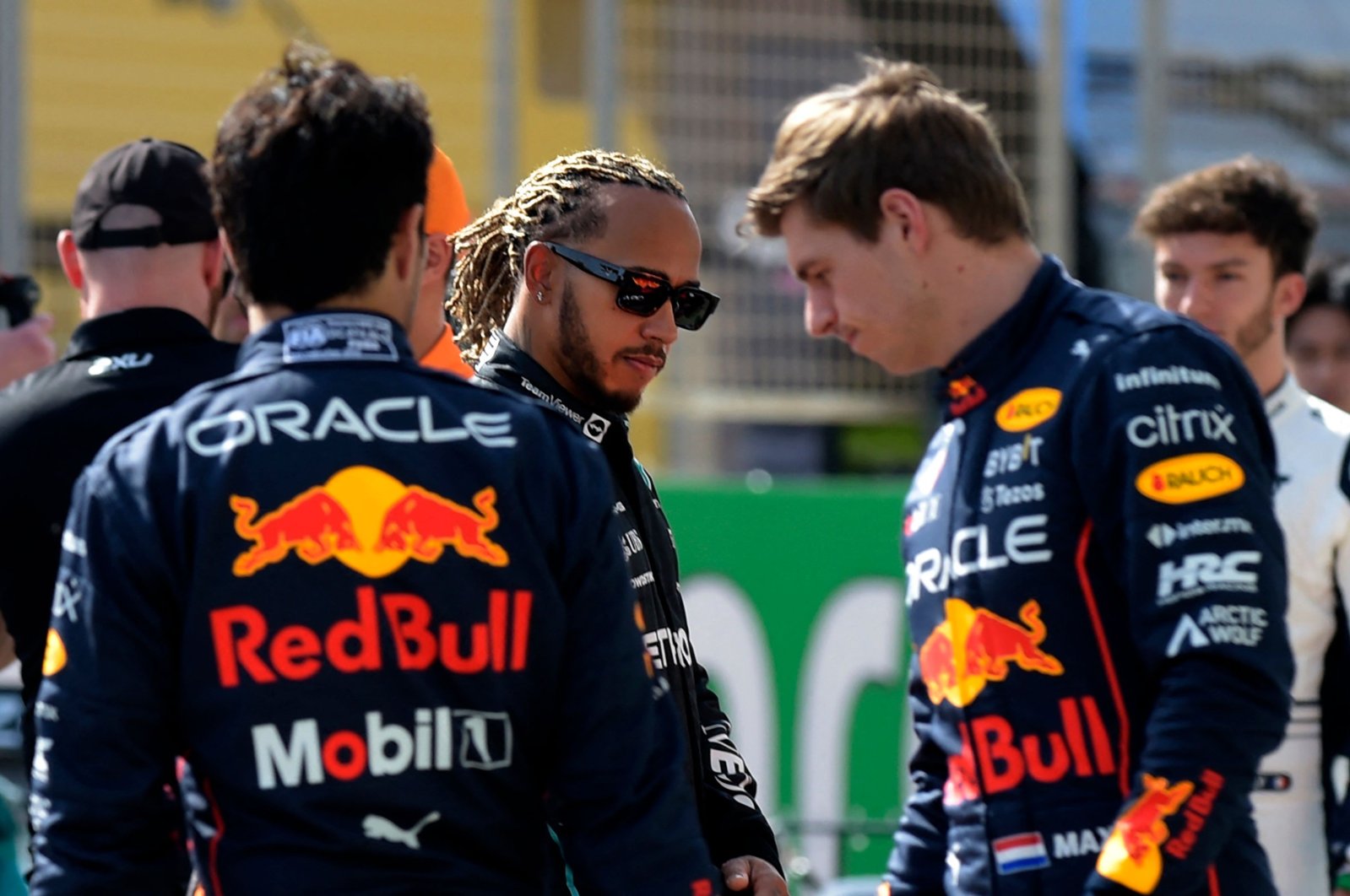 Mercedes&#039; Lewis Hamilton (C) walks past Red Bull&#039;s Max Verstappen (R) during the first day of F1 preseason testing, Sakhir, Bahrain, March 12, 2021. (AFP Photo)