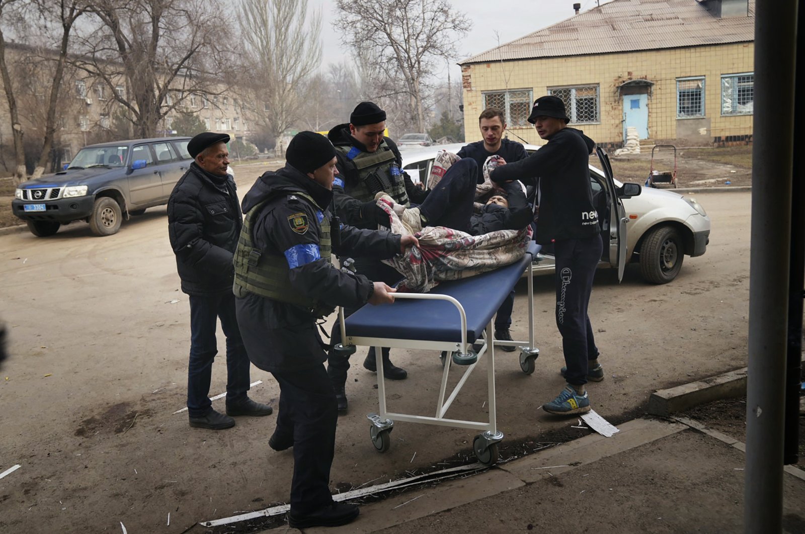Ukrainian soldiers and volunteers carry a man injured during a shelling attack into hospital number 3 in Mariupol, Ukraine, March 15, 2022. (AP File Photo)